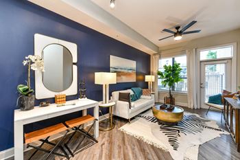 a living room with a blue accent wall and a mirror